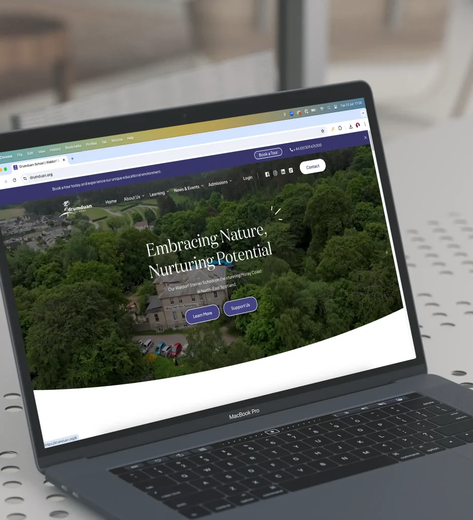 A laptop screen displays a webpage with the headline "Embracing Nature, Nurturing Potential" against a backdrop of a green landscape. The site has menu options and buttons for learning more and supporting.